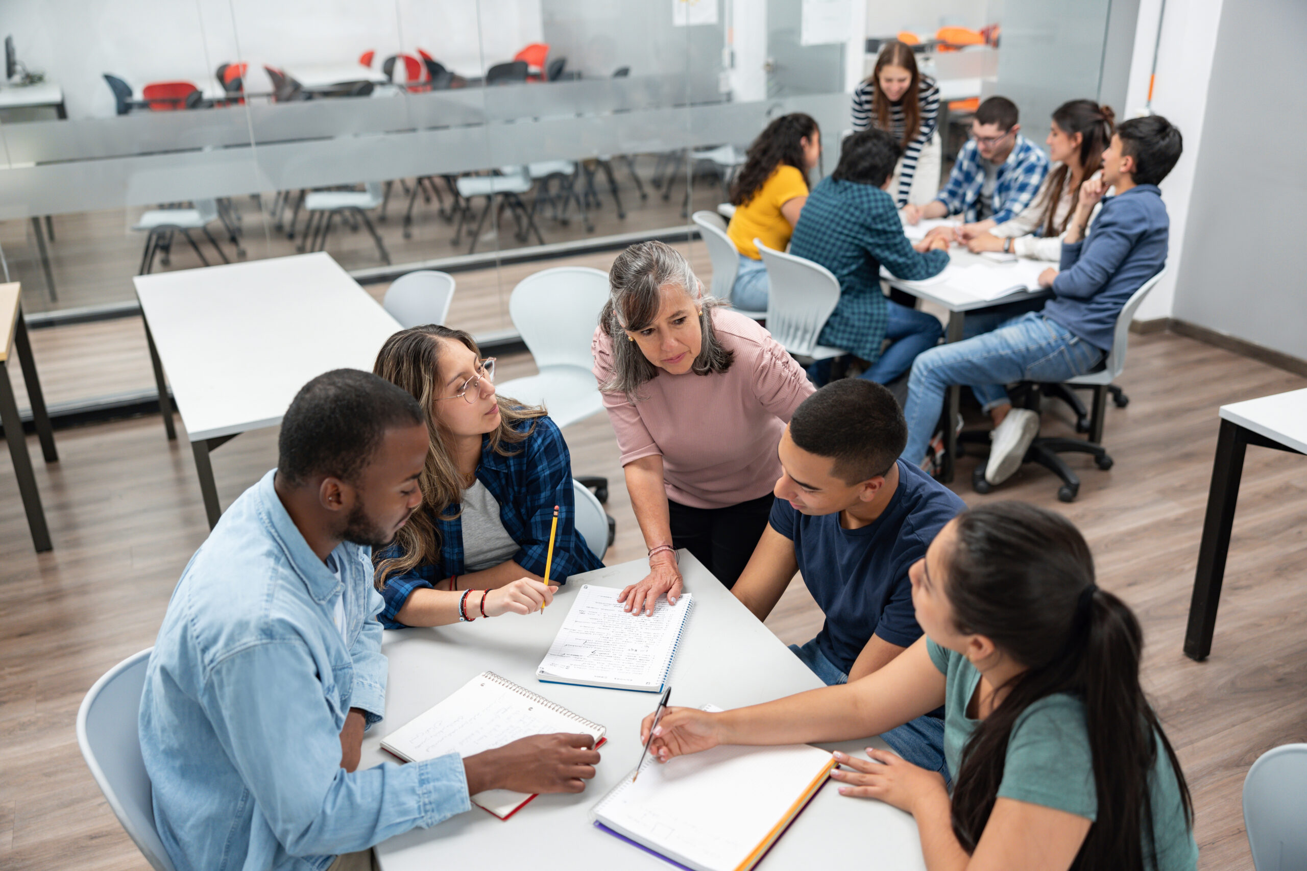 Teacher in class explaining something to a group of students Teacher in class explaining something to a group of students